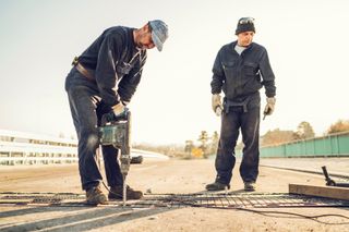 Workers Repairing Bridge With A Drill — Jonesboro, AR — Anderson Engineering Consultants Inc Workers Repairing Bridge With A Drill — Jonesboro, AR — Anderson Engineering Consultants Inc