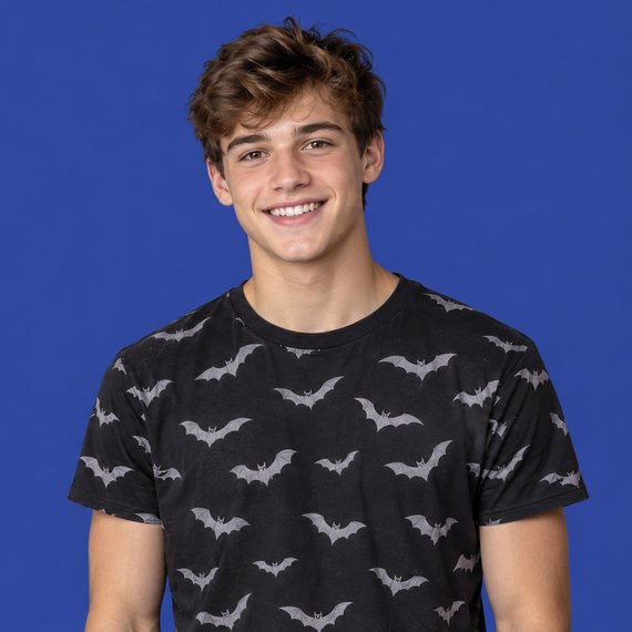 Smiling person in a black bat-pattern shirt against a blue background