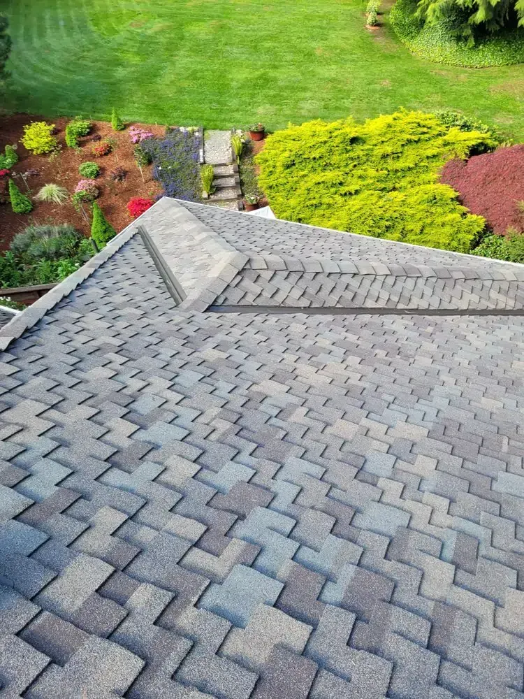 Gray shingled roof with a landscaped garden and stone path below