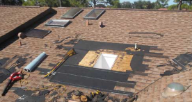 Roof being repaired, showing skylights, tools, and exposed underlayment.
