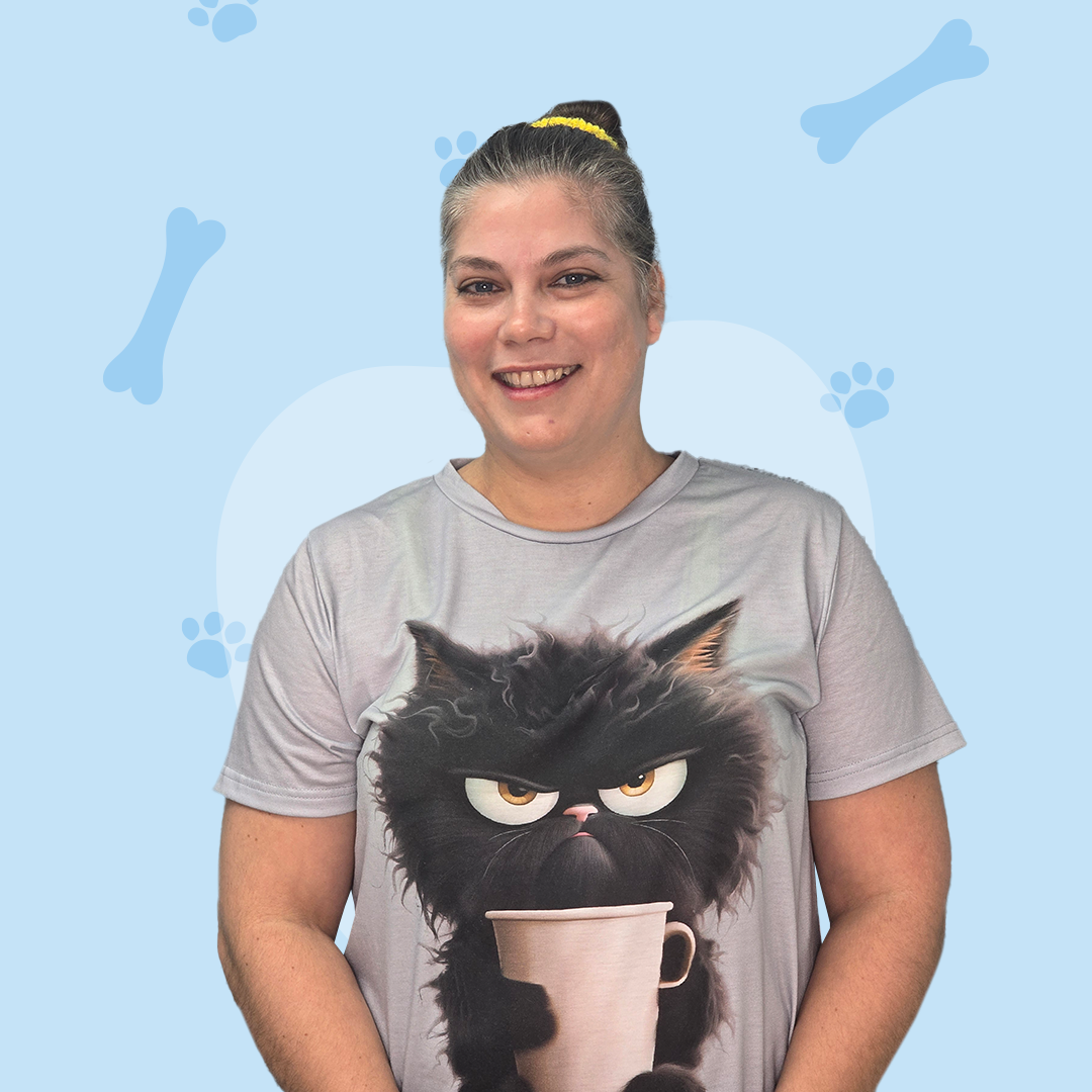 A woman is wearing a t-shirt with a black cat holding a cup of coffee.