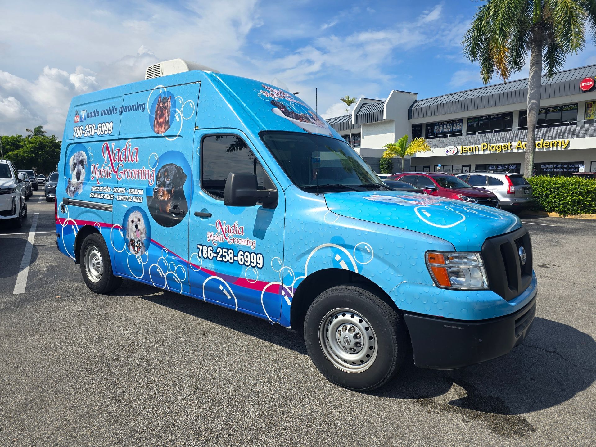 A blue ice cream truck is parked in a parking lot.