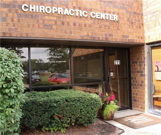 Chiropractic Center entrance with brick exterior and glass door. Signage above the door reads