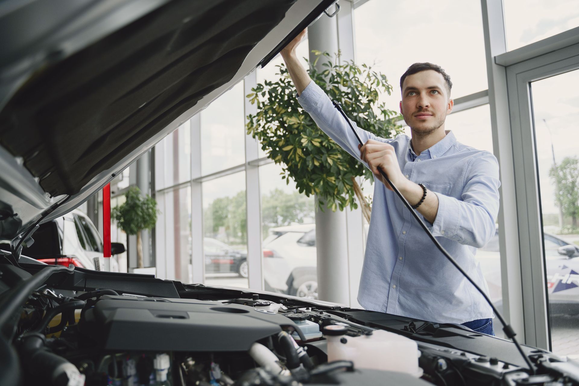 A customer looking at their car in a dealership environment
