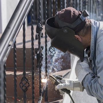 Professional Worker Installing Iron Railing Professional Worker Installing Iron Railing