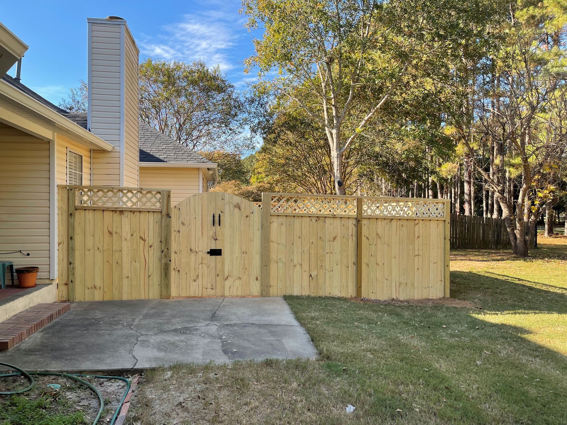 A house with a driveway and a brick wall in front of it.