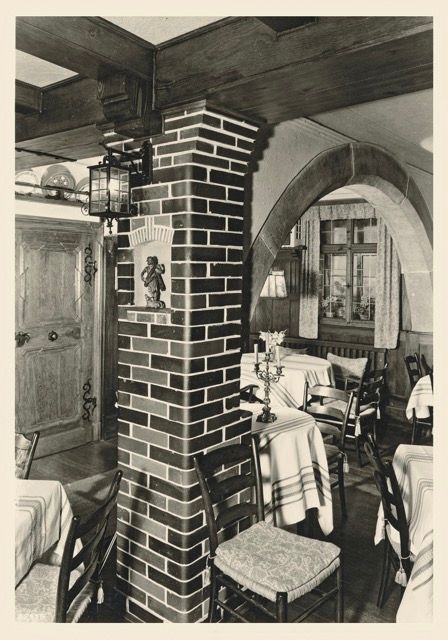 Ein Schwarzweißfoto eines Restaurants mit Tischen und Stühlen