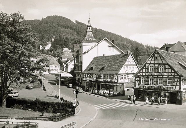 Ein Schwarzweißfoto einer Kleinstadt mit einer Kirche im Hintergrund