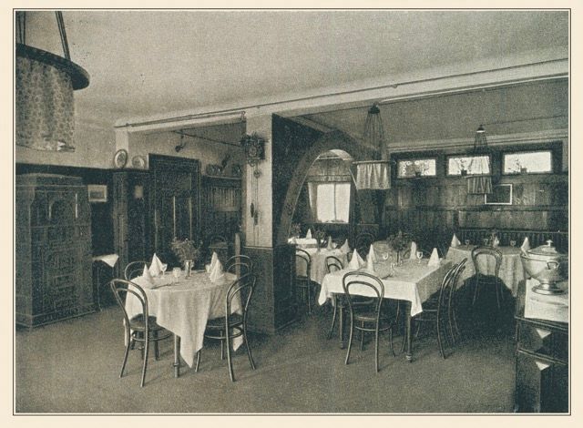 Ein Schwarzweißfoto eines Restaurants mit Tischen und Stühlen