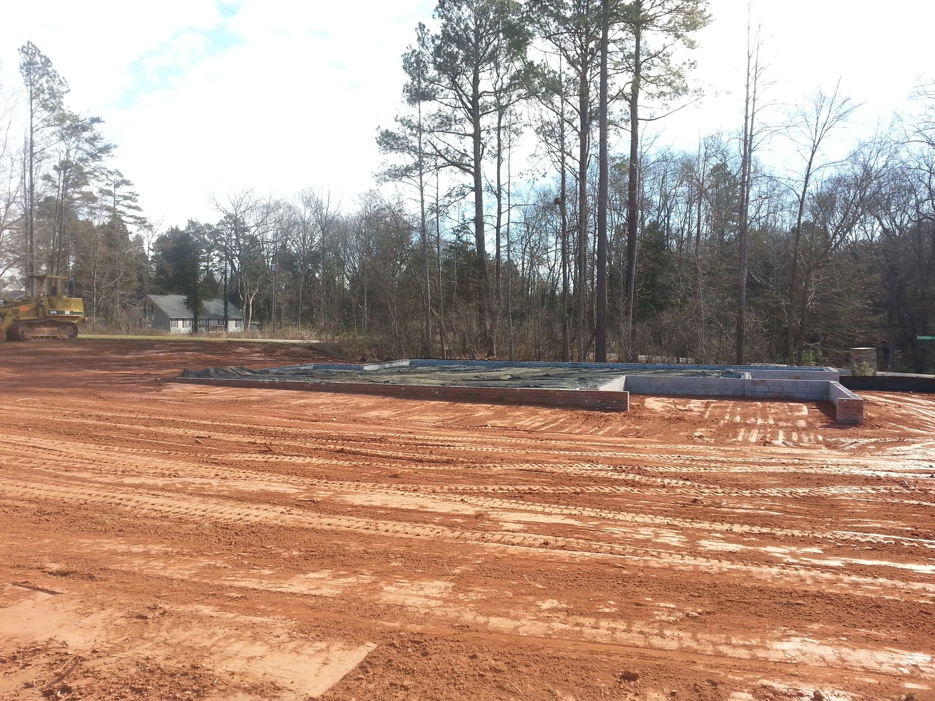 A large dirt field with trees in the background