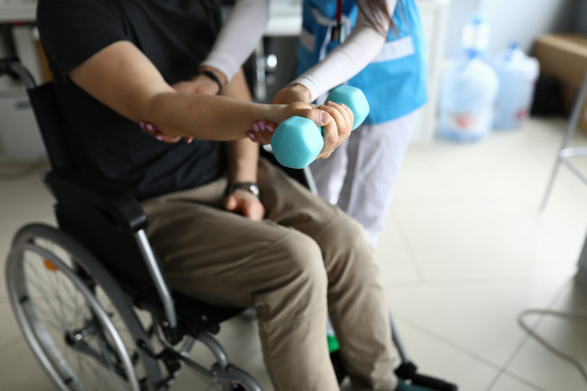 Person in a wheelchair holding a blue stress ball during a therapy session
