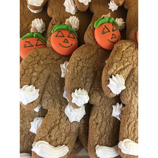 A bunch of gingerbread men with pumpkins on their heads.