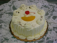 A white cake with a cherry on top of it