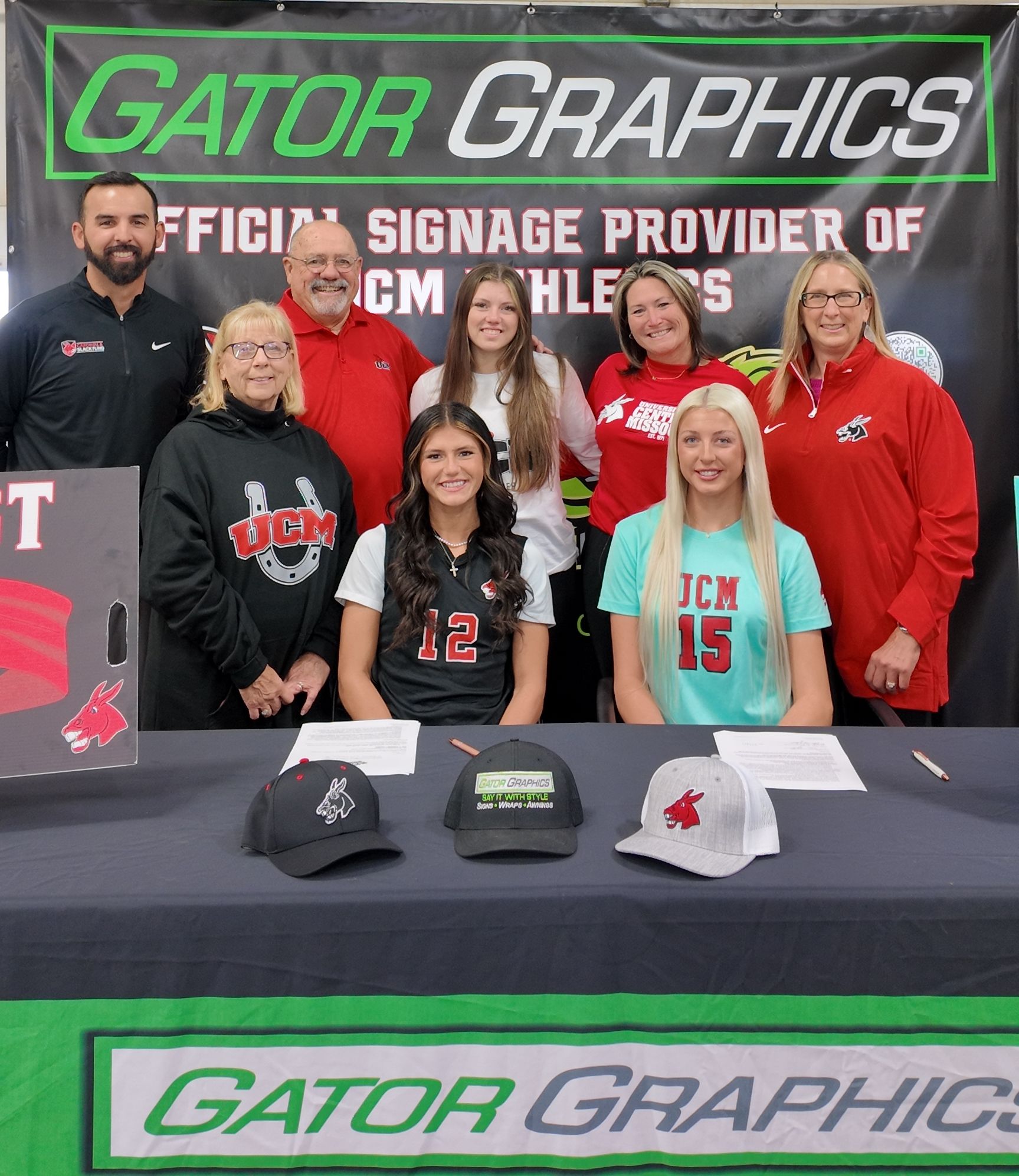 Mikayla Ernst and Kristen Wright of the Jenny's posing with their families at Gator Graphics booth.