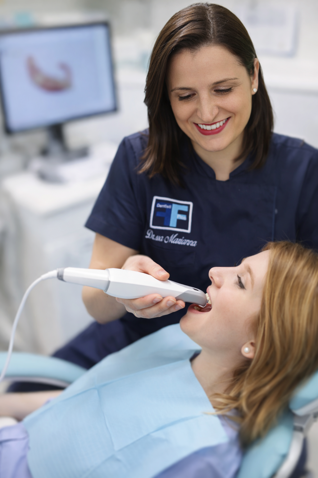 Dentista che esegue impronta digitale con scanner intraorale su paziente in studio odontoiatrico