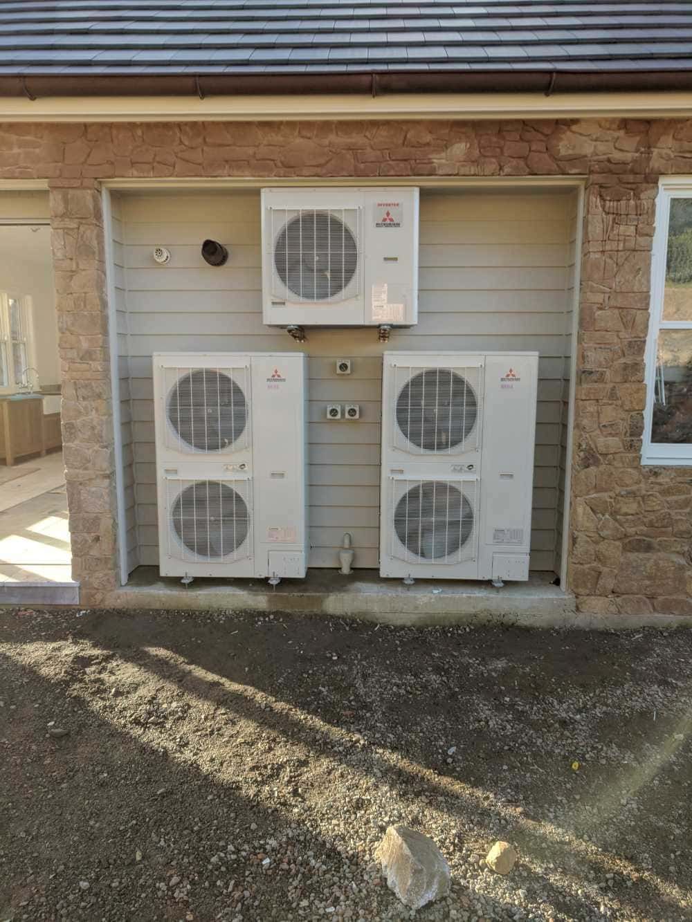 Two Air Conditioners Are Mounted on the Side of a Building — Cool Heat Air Conditioning in Kiama, NSW