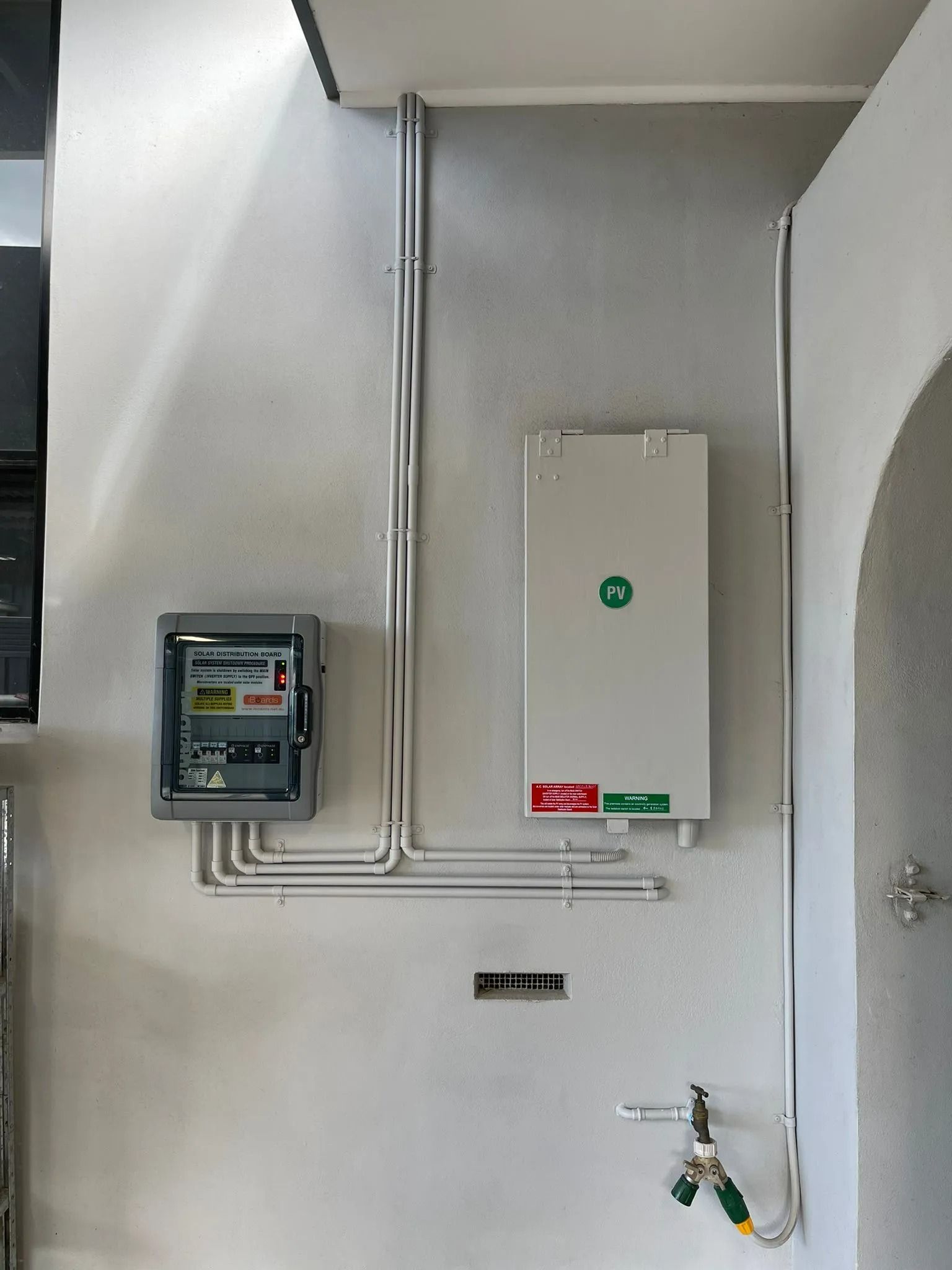 A White Wall With a Box and Pipes on It — Cool Heat Air Conditioning in Kiama, NSW