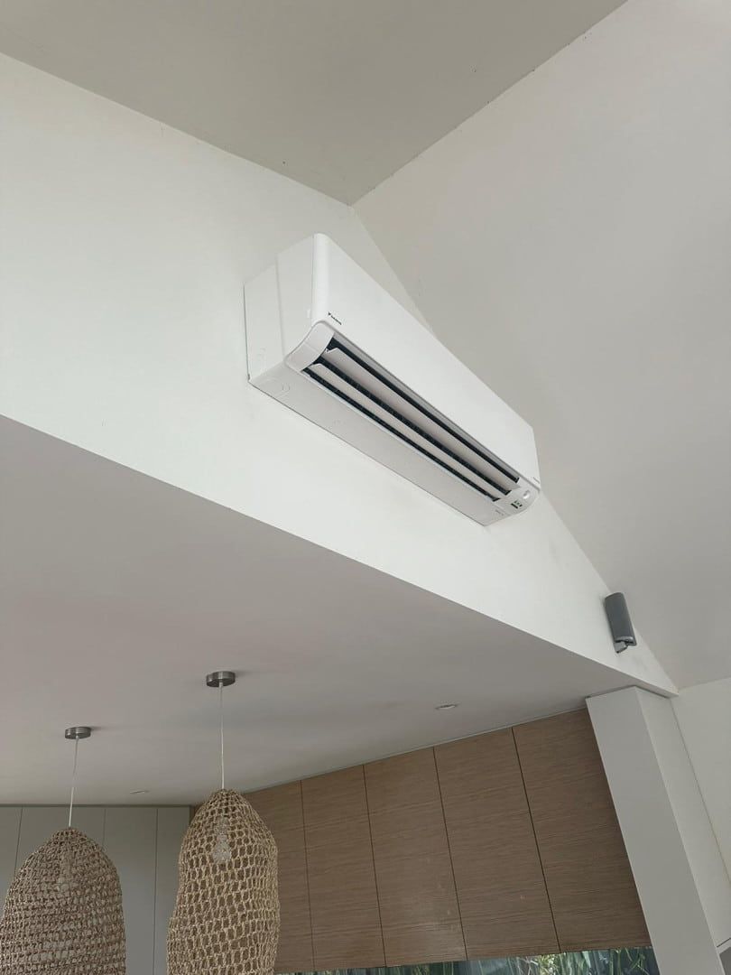 A White Air Conditioner is Hanging From the Ceiling of a Room — Cool Heat Air Conditioning in Albion Park, NSW