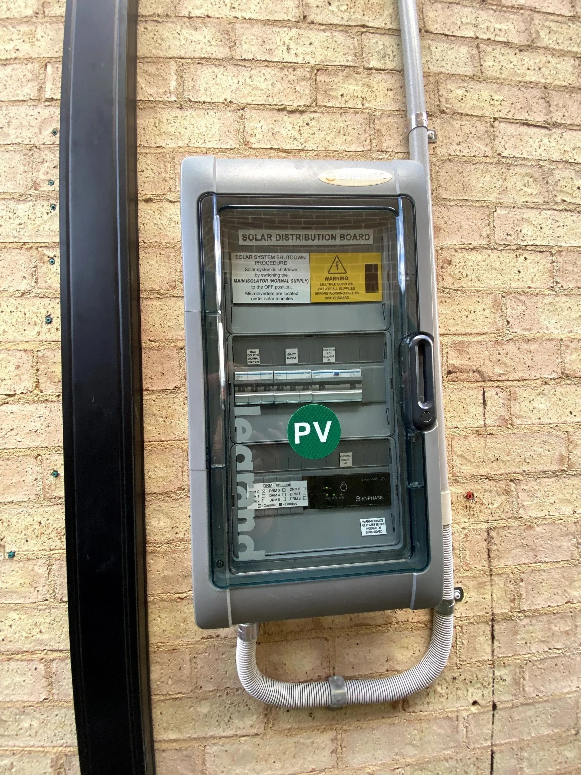 An electrical switchboard on a brick wall — Cool Heat Air Conditioning in Albion Park, NSW