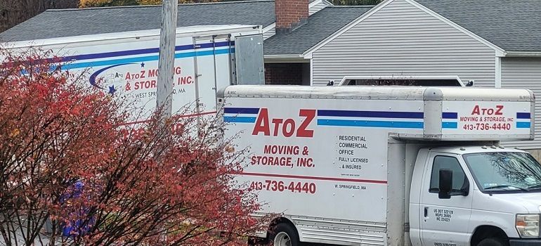 Two A to Z Moving trucks parked beside a building, with red and blue company lettering.
