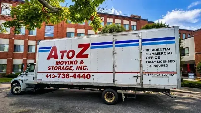 AtoZ Moving & Storage truck parked in front of a red brick building.