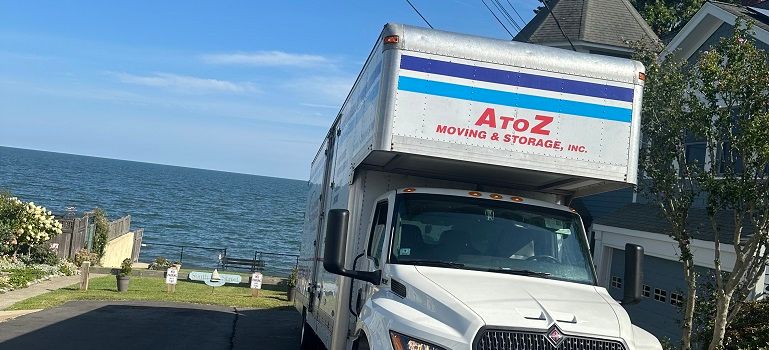 Delivery truck parked by the ocean with blue water in the background
