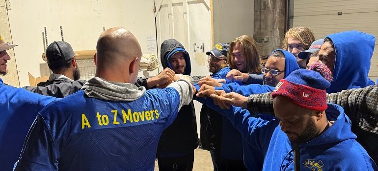 Moving crew in blue shirts and gloves teamwork-lifting or passing items in a doorway