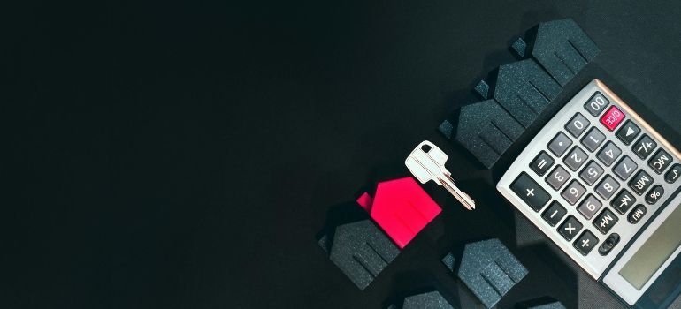 Calculator on dark fabric beside a bright red USB flash drive and white connector