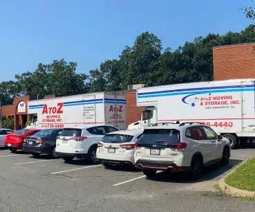 Parked cars outside A to Z Moving and Storage trucks on a sunny day
