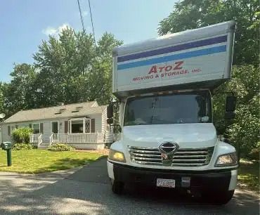 White moving truck with A to Z logo parked in front of a house on a sunny street