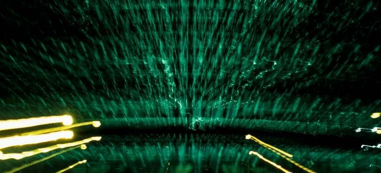 Blurred neon green and yellow light trails streak through a dark tunnel-like scene