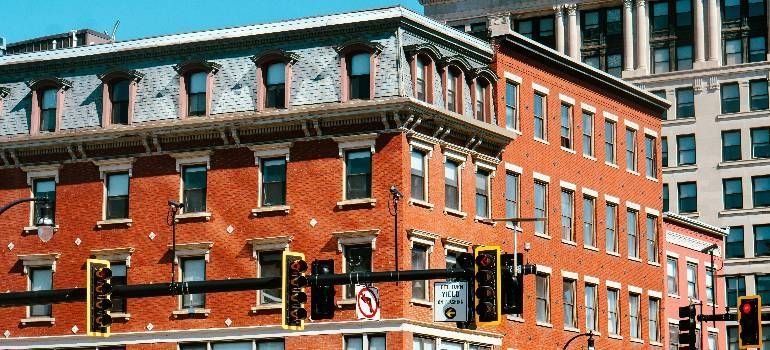 Red brick corner building with white trim and large windows at a city intersection