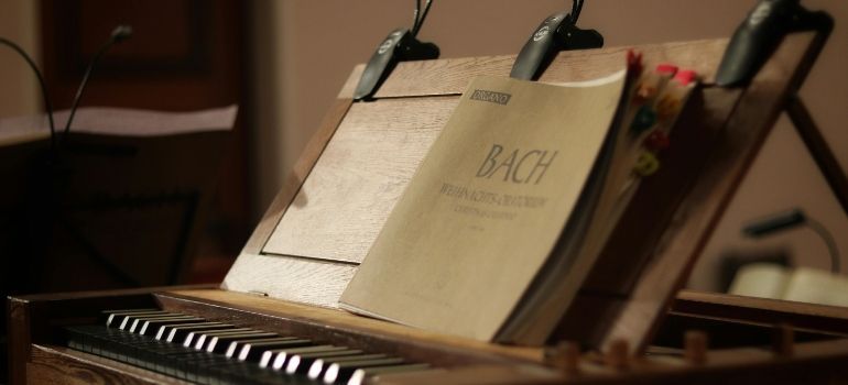 Sheet music on stands above a piano keyboard in a warm, dimly lit room