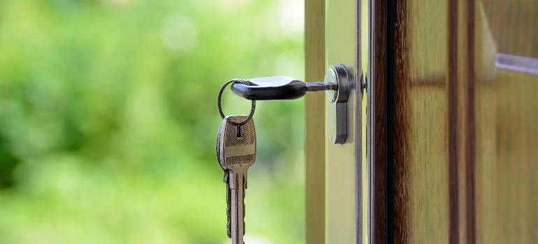 Key in a door lock on a wooden door with blurred green background