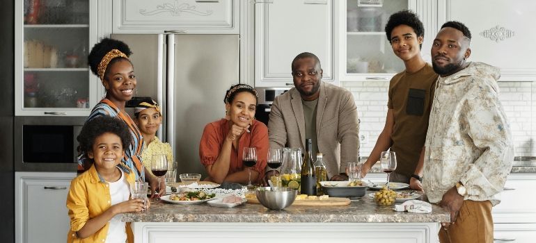 Family gathered around a kitchen island, smiling and sharing a meal together