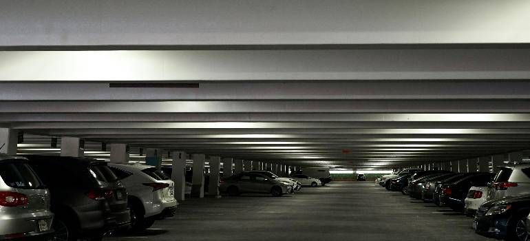 Dimly lit underground parking garage with rows of parked cars on both sides