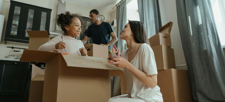 People packing boxes in a bright living room during a move