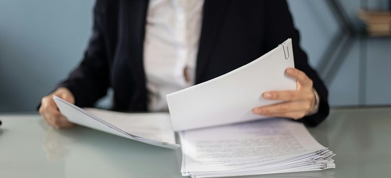 Hands flipping through a stack of papers at a desk