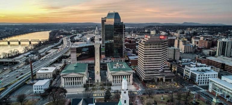Aerial view of a downtown skyline at sunset with a river and bridges in the distance