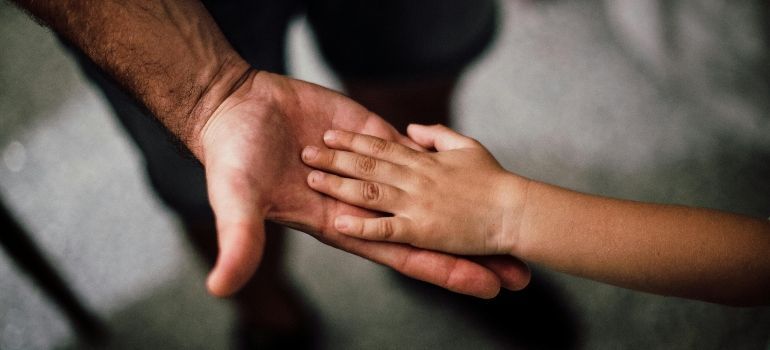 Two hands gently holding against a blurred dark background