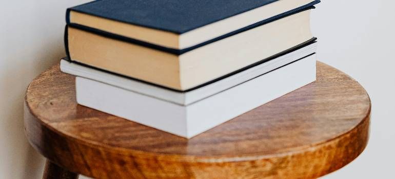 Stack of three hardcover books on a round wooden table