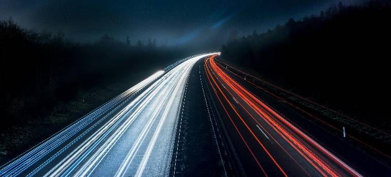 Long-exposure highway at night with white and red light trails