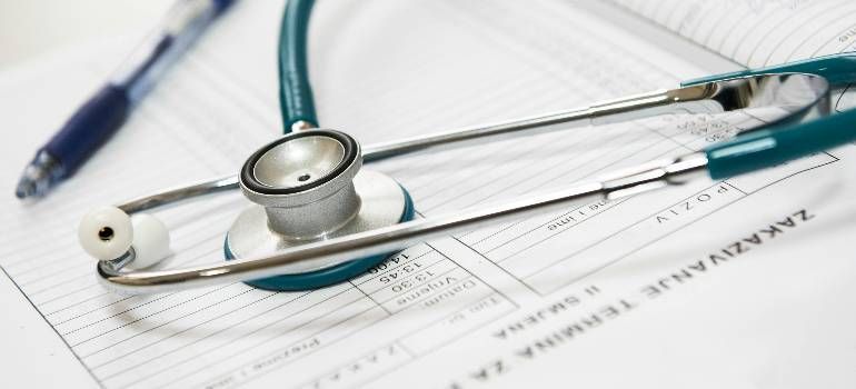 Stethoscope on a medical form with a pen, suggesting healthcare paperwork