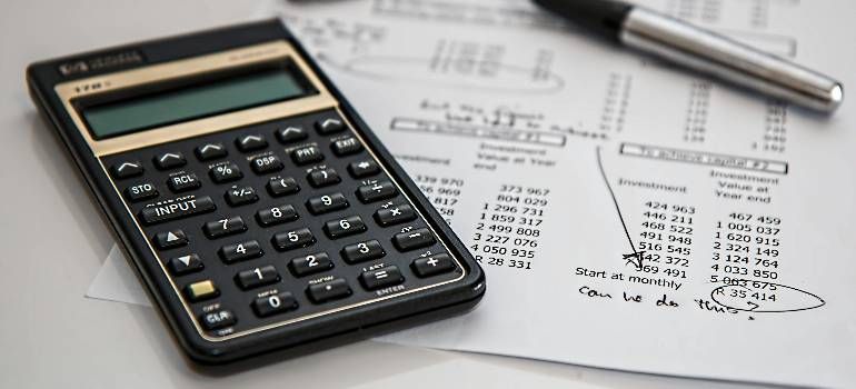 Calculator on financial paperwork with a pen nearby