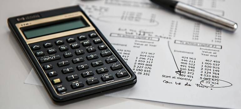 Calculator on financial paperwork with pen nearby