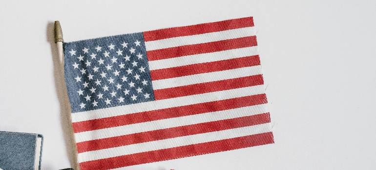 American flag with red and white stripes and blue field of stars hanging indoors.