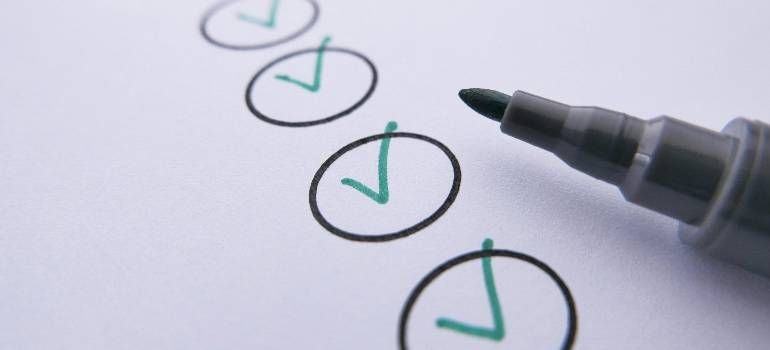Pen checking off a list of circled tasks with teal check marks