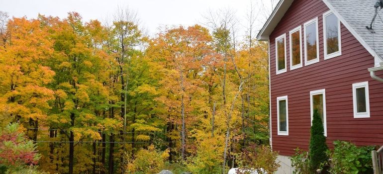 Red house beside autumn trees with yellow and orange foliage
