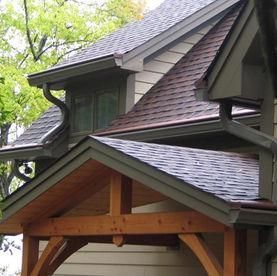 A wood-framed porch entrance sits below a house roof with dark shingles.