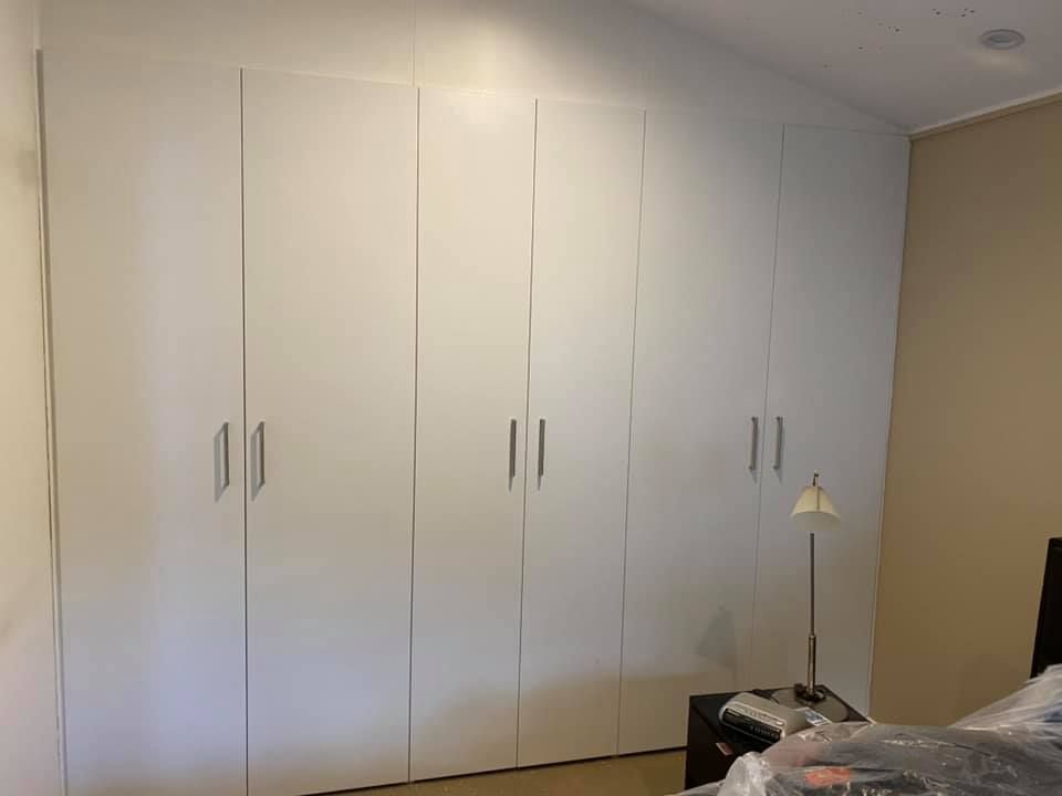 A Bedroom with A Lot of White Cabinets and A Bed — P & M Maintenance Building Services in Yass River, NSW